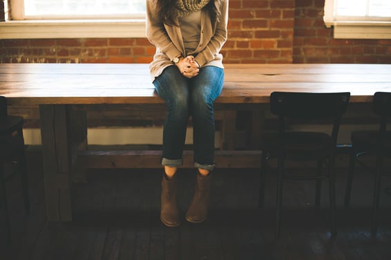 Girl sitting on a desk alone